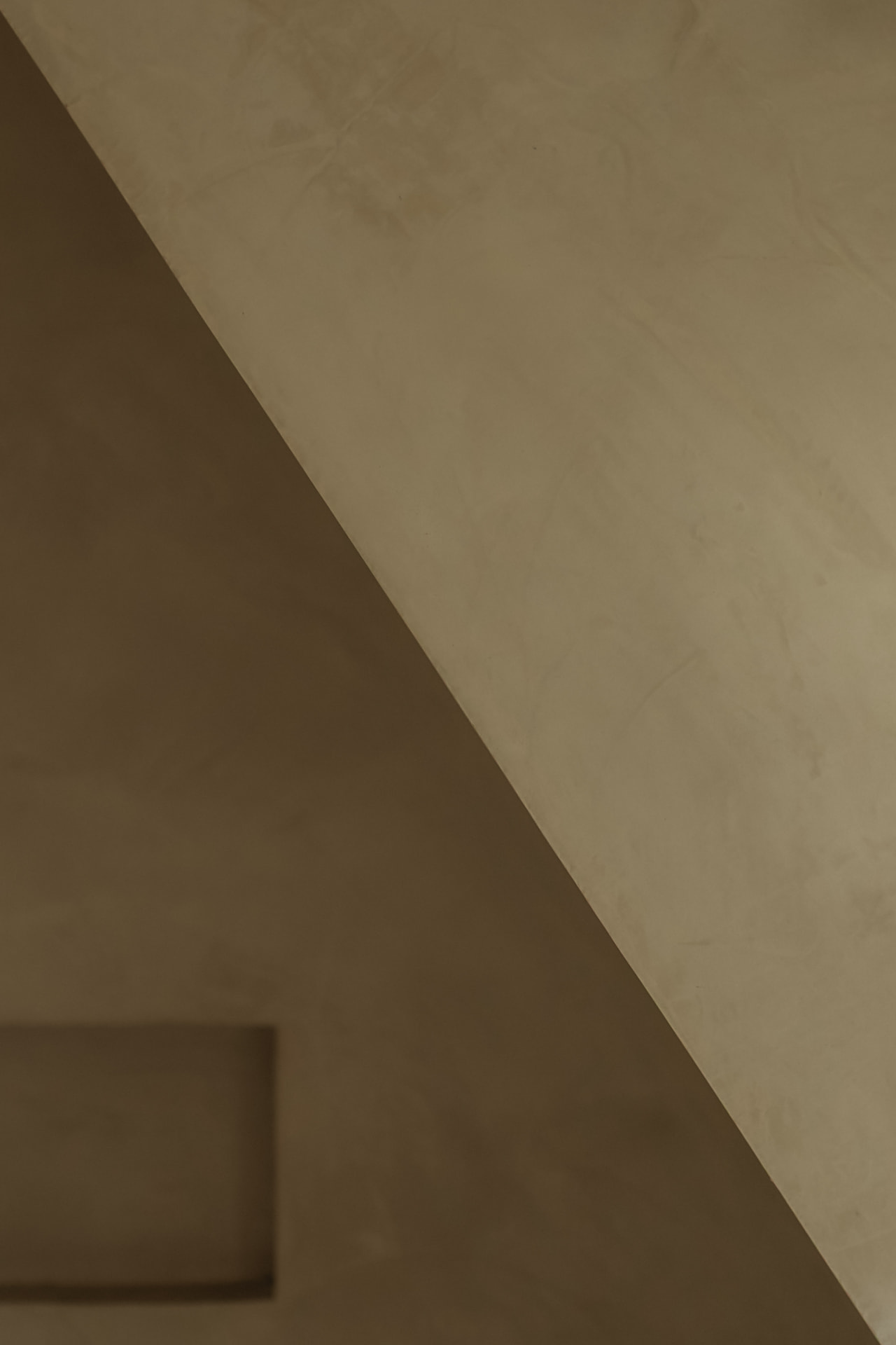 Recessed wall niche set into deep taupe plaster beside a lit shower alcove